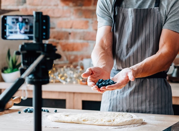 2021 PPC Best Practices - High-quality video remains a valuable part of PPC engagement strategy. Chef holds blueberries to the camera in kitchen