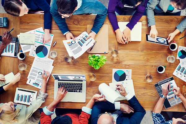 Google's Broad Match Modifier update and its effect on PPC campaigns - aerial view of marketers at a conference table