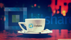 The bitshares logo is pictured printed on a coffee cup against a backdrop featuring the same logo