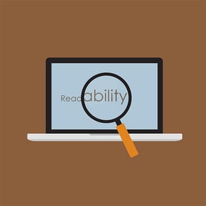 Low readability can lead to higher bounce rates. Readability written on laptop screen with “ability” larger under a magnifying glass.
