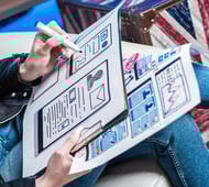 A core component of web design strategy is layout. A woman sketches a webpage design and layout
