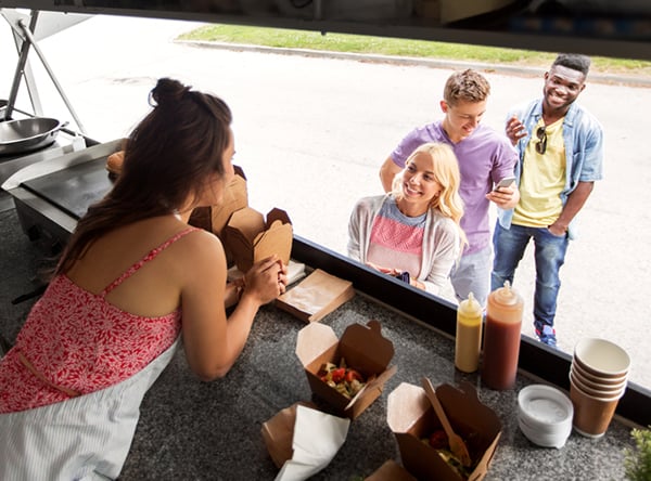 Use your existing feedback to increase website conversions - a woman talks to customers from a food truck window