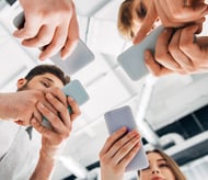 One strategy to increase website conversions is to make sure your site is mobile-friendly. Four people look at their phones